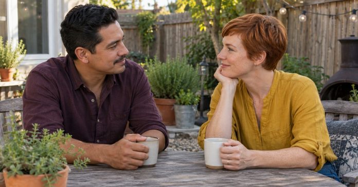 Two adults talking attentively across a table on a home patio